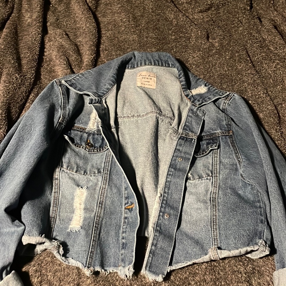 Distressed blue denim jacket cropped.